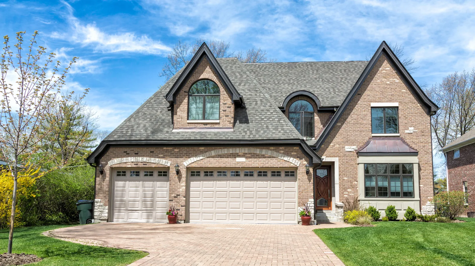 Brick two-story with steep gables and a gray architectural shingle roof
